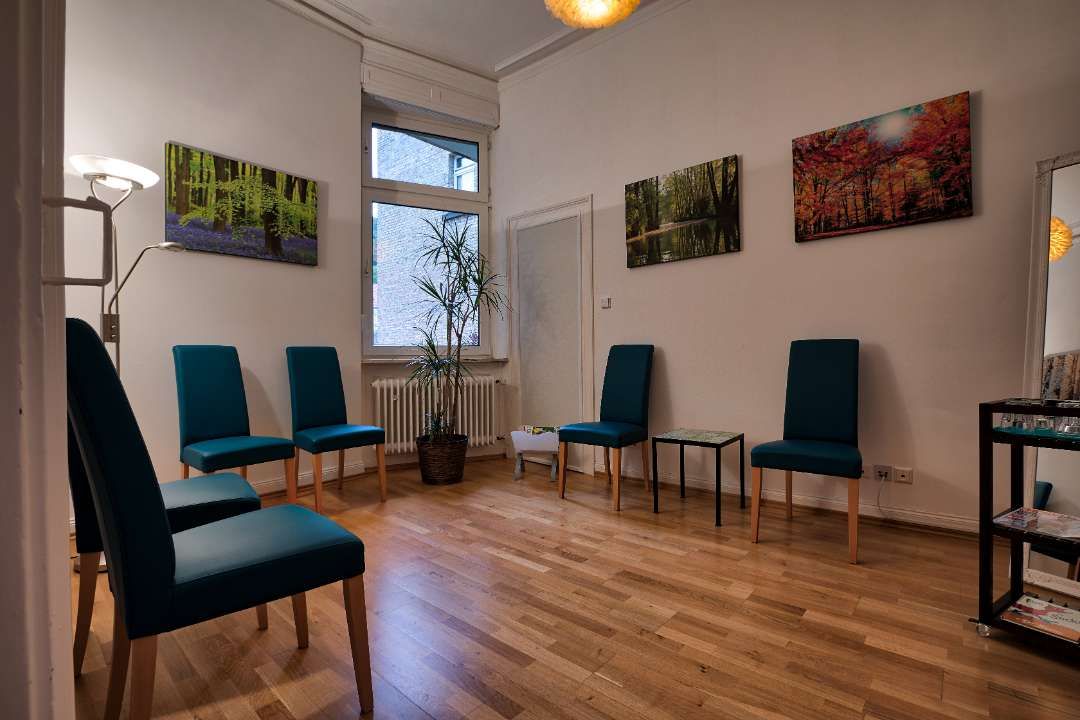 Wartezimmer mit Stühlen und Bildern an der Wand